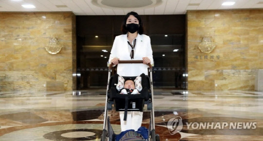 기본소득당 용혜인 의원이 5일 생후 59일 아들과 함께 5일 서울 여의도 국회에 '출산 후 첫 등원'을 해 로텐더홀을 지나고 있다.<연합뉴스>